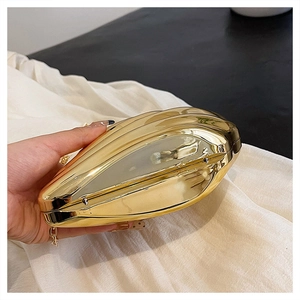 Detailed close-up of the metal hinge and glossy gold plating on the shell evening bag