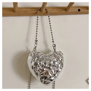 Detail of silver heart-shaped mini bag with liquid metal ripple texture and bead chain