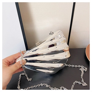 Close-up of silver acrylic shell clutch bag with metallic wave texture and chain