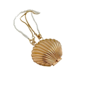 Elegant gold shell acrylic evening bag with pearl handle and metal chain strap