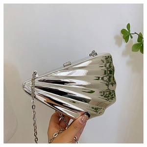 Detailed view of silver seashell evening clutch with textured shell pattern and chain strap