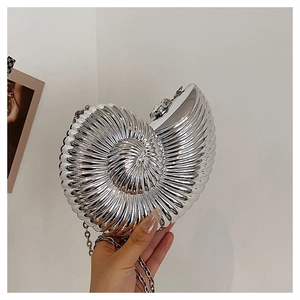 Detailed view of a silver shell-shaped evening clutch bag with metallic spiral texture
