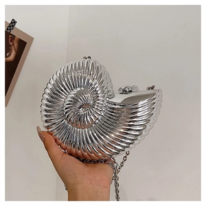 Detailed view of silver nautilus-shaped clutch bag with textured metal and chain strap