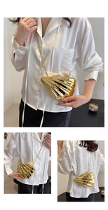 Detailed close-up showing the metallic shell-shaped evening clutch and gold chain strap