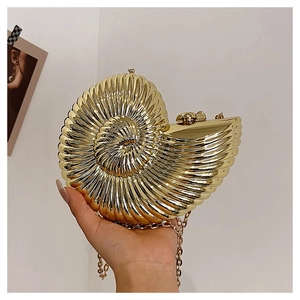 Detail of gold shell evening bag with nautilus stripes and sleek metal chain