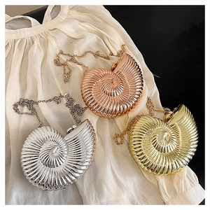 Detail of snail shell evening bags in gold, silver, and rose gold with chain straps