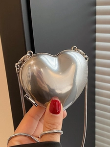 Mini silver heart-shaped acrylic crossbody bag with sleek metallic chain strap