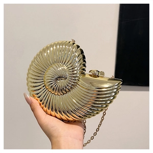 Detailed macro view of golden nautilus evening clutch with shell texture and rhinestone clasp