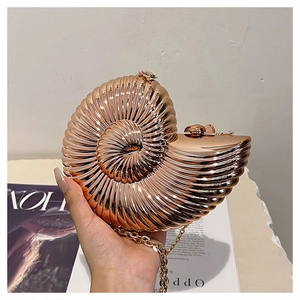 Detail of conch shaped rose gold evening bag with 3D spiral texture and gold chain