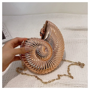 Detail of rose gold seashell clutch bag with metallic texture and removable chain strap