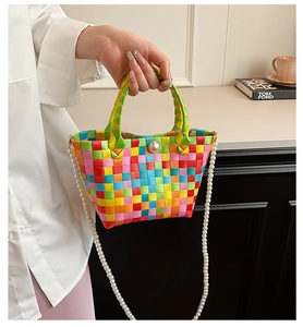 Détail d'un sac cabas tissé coloré à damier avec bandoulière et boucle en perles