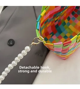 Détail du fermoir mousqueton doré amovible et de la bandoulière tissée colorée