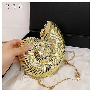 Detailed macro view of the gold seashell evening bag with metallic spiral texture