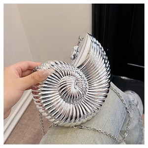 Detail of silver conch shell clutch bag with metallic spiral texture and chain strap