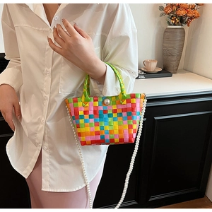 Détail d'un sac à main tissé coloré avec bouton perle et bandoulière en perles