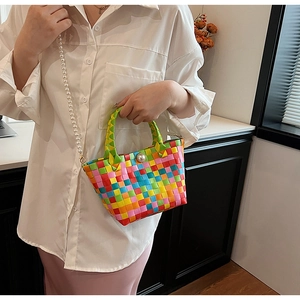 Détail d'un sac panier tissé multicolore avec bandoulière et fermoir en perles