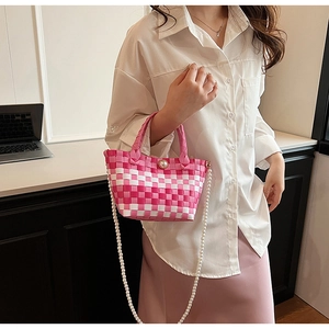 Sac à main tissé à carreaux rose et blanc avec bandoulière en perles porté par un mannequin