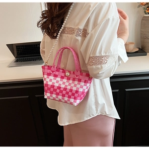 Détail du sac tissé à damier rose avec bandoulière en perles et boucle de perle élégante