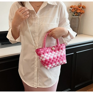 Détail d'un sac à main tissé à carreaux roses et blancs avec bandoulière en perles