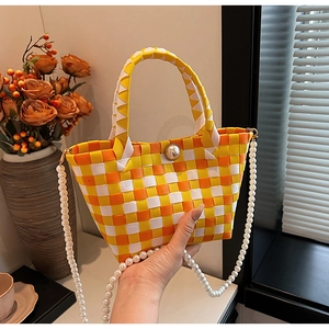 Détail du sac cabas tressé à carreaux orange et jaune avec fermoir et bandoulière perle