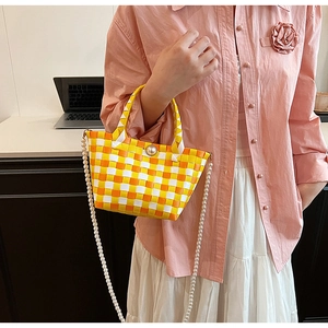 Détail d'un sac cabas tissé à carreaux avec boucle perle et longue bandoulière perle