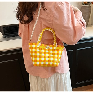 Détail du sac à main tissé avec poignée en perles et bandoulière élégante en perles