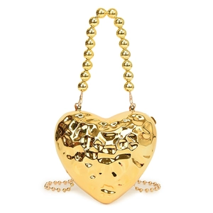 Golden heart-shaped metallic evening bag with hammered texture and large bead handle