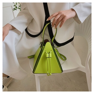Detail of neon green pyramid handbag with matte leather finish and drawstring closure