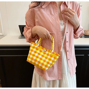 Détail du mini sac à damier tissé main avec boucle en perle et bandoulière