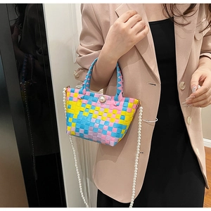 Détail du panier tissé coloré avec bouton perle et bandoulière en chaîne de perles