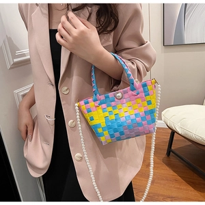 Détail d'un sac panier tissé à la main avec poignées en perles et bandoulière élégante