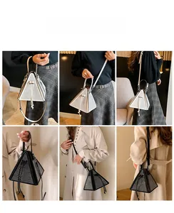 Détail du sac à main triangulaire à strass montrant les styles bandoulière et porté main