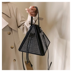 Détail d'un sac à main triangulaire noir avec strass argentés et bandoulières en cuir