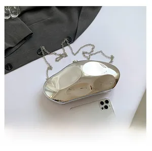 Detail view of silver pebble-shaped evening bag with metallic chain and mirror finish