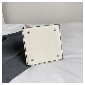 Détail du fond de sac blanc avec quatre rivets de protection en métal argenté brillant