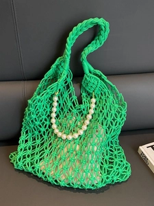 Detail of bright green woven mesh beach bag with pearl strap and inner pouch