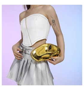 Close-up of golden irregular stone-shaped clutch bag with sleek metal chain detail