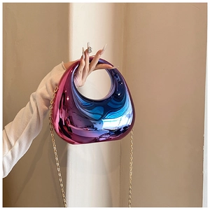Detail of half-moon acrylic clutch with pink to blue gradient metallic finish and chain