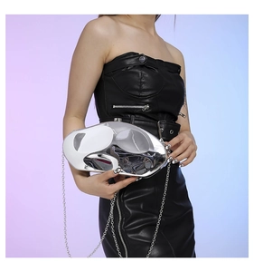 Detail of silver liquid metal evening clutch bag with mirrored finish and chain strap