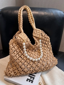 Detail of summer mesh woven tote bag featuring an elegant pearl bead handle and inner lining