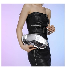 Close-up of a silver acrylic stone clutch bag with mirror finish and metal chain
