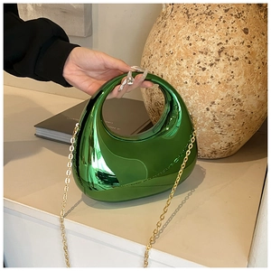 Detail of green acrylic half-moon evening bag with metallic finish and gold chain