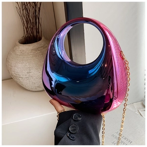 Close-up of a metallic gradient acrylic clutch bag with round handle and metal chain
