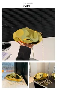 Macro detail of golden irregular pebble-shaped clutch bag with metal chain strap
