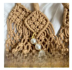Detailed view of khaki mesh bag featuring a gold clasp and pearl charm with rhinestones