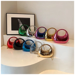 Multiple colorful acrylic moon handle clutch bags displayed on a white step stand with chains