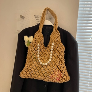 Macro view of macrame hollow bag with elegant pearl strap and black inner lining