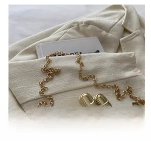 Detailed close-up of a golden palm-shaped clutch with a fine metal chain strap