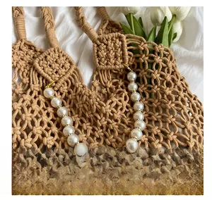 Detailed close-up of woven mesh beach bag with white pearl chain and metal accents