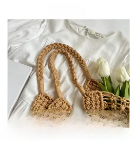 Detail of hand-woven mesh bag featuring pearl pendant and thick shoulder strap